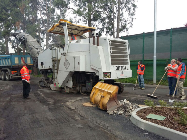 Uomini al lavoro per realizzare costruzioni stradali con la fresatrice stradale